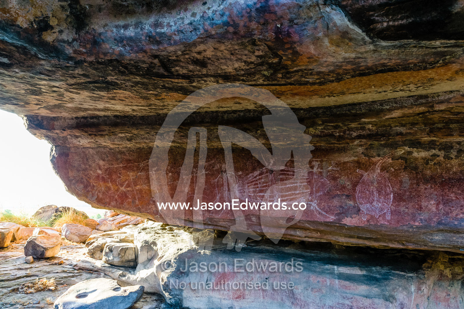 Aboriginal rock painting of human figures hunting, fish and turtles in an overhang gallery on a sandstone escarpment. Ubirr, Kakadu National Park, Northern Territory, Australia.