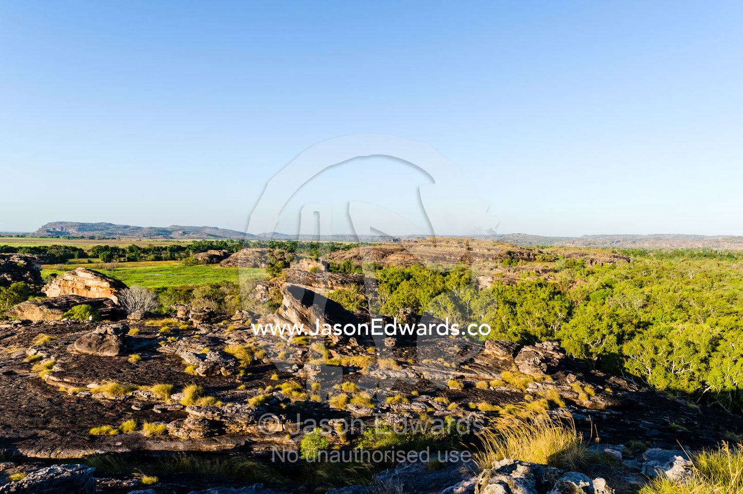 A rugged sandstone escarpment overlooking a floodplain at sunset. Ubirr, Nadab floodplain, Kakadu National Park, Northern Territory, Australia.