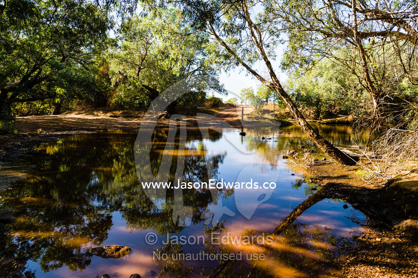 An outback track crosses a flooded river in Kadadu National Park. Kakadu National Park, Northern Territory, Australia.