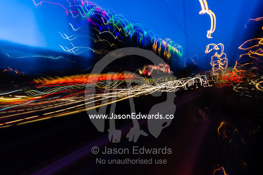 The blurred headlights of cars racing along a city street. Tehran, Tehran Province, Islamic Republic of Iran.