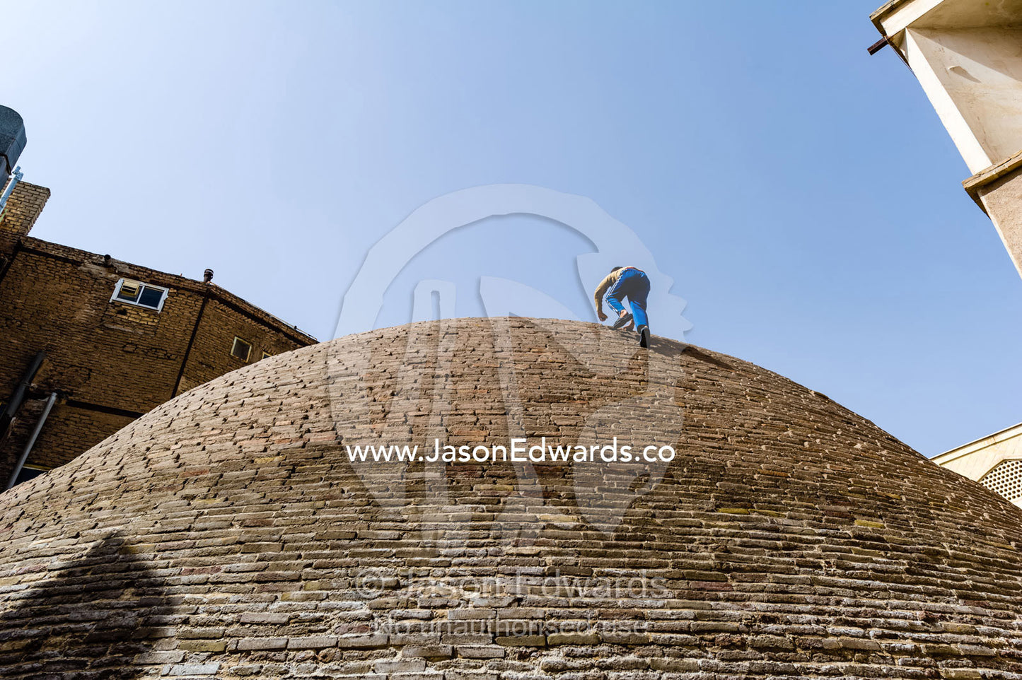 Children climb the steep sides of an ancient handmade brick cistern containing town water. Kashan, Isfahan Province, Islamic Republic of Iran.