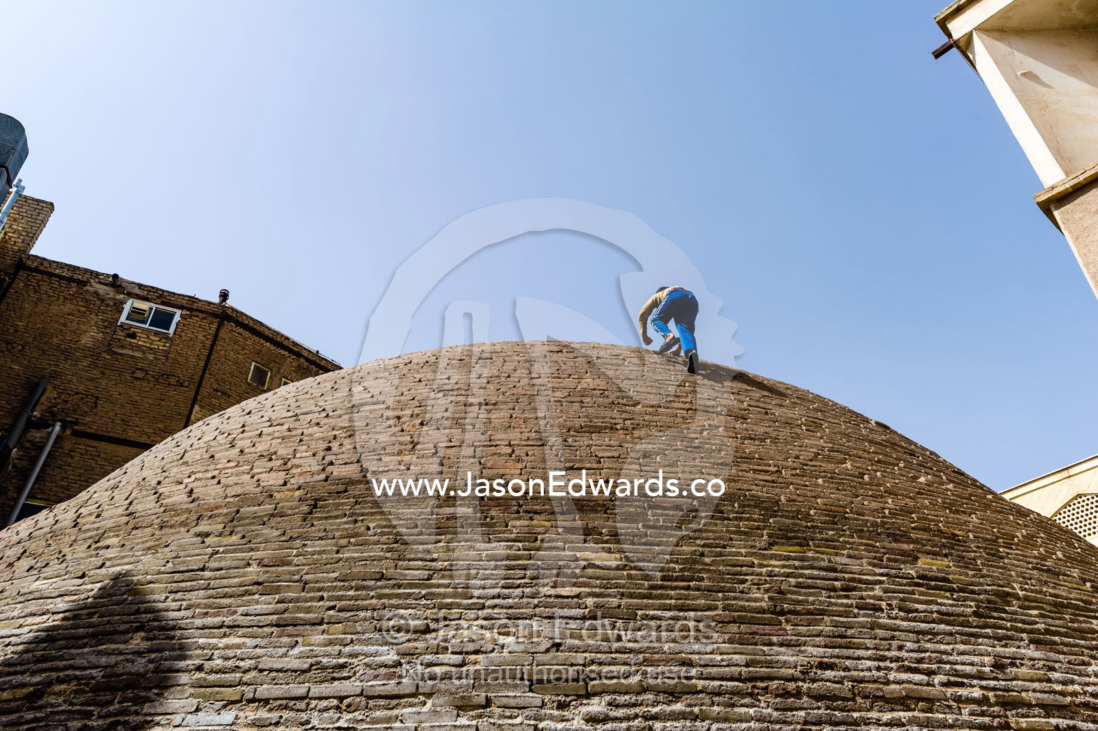Children climb the steep sides of an ancient handmade brick cistern containing town water. Kashan, Isfahan Province, Islamic Republic of Iran.