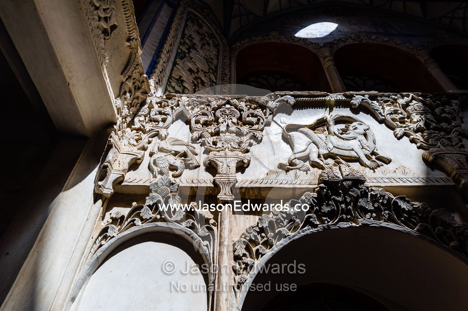 A plaster stucco features a lion fighting with a dragon surrounded by flowers. Borujerdis House, Kashan, Isfahan Province, Islamic Republic of Iran.