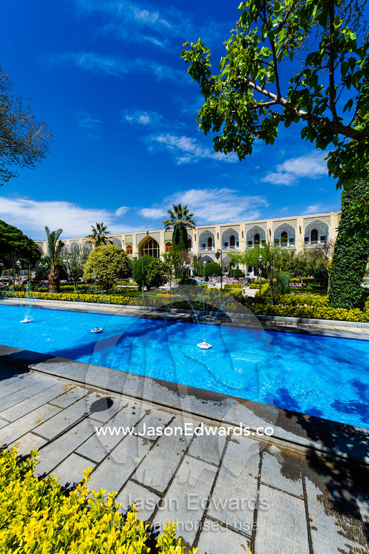 An ornamental pond with fountains and traditional garden in a caravanserai converted into a boutique hotel. The Abbasi Hotel, Isfahan, Isfahan Province, Islamic Republic of Iran.