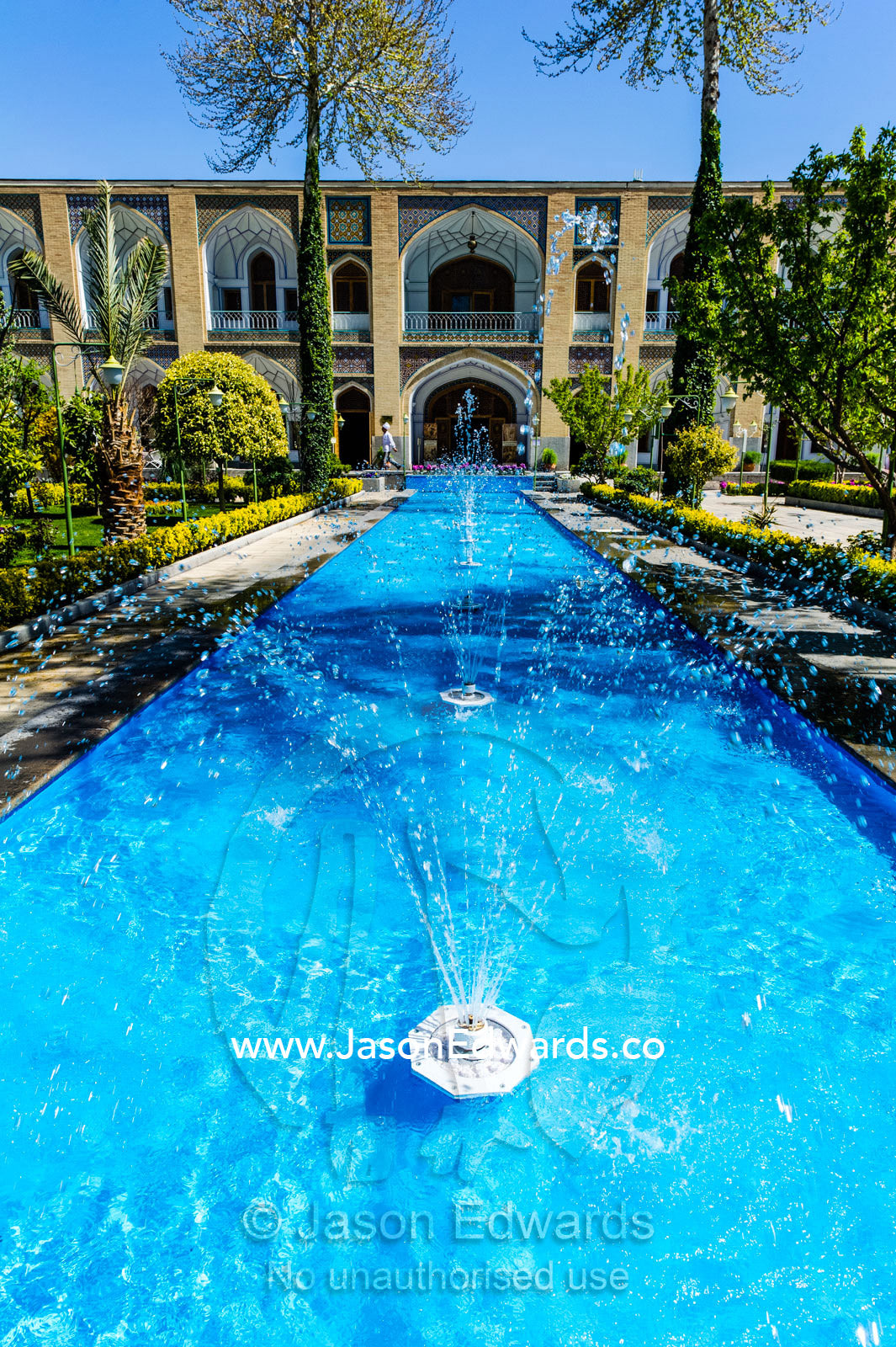 An ornamental pond with fountains and traditional garden in a caravanserai converted into a boutique hotel. The Abbasi Hotel, Isfahan, Isfahan Province, Islamic Republic of Iran.