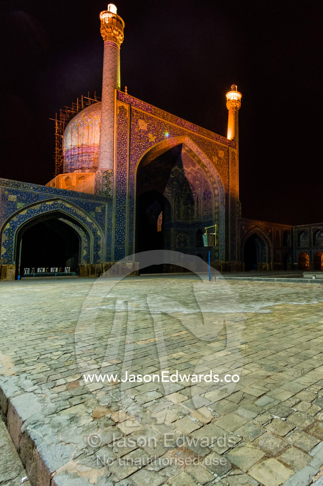 The courtyard and vaulted iwan of the Shah Mosque illuminated at night. Shah Mosque, Isfahan, Isfahan Province, Islamic Republic of Iran.