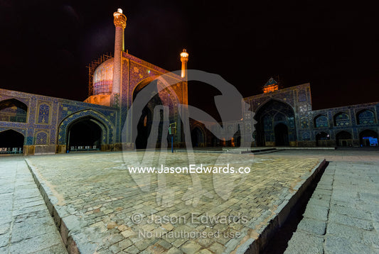 The courtyard and vaulted iwan of the Shah Mosque illuminated at night. Shah Mosque, Isfahan, Isfahan Province, Islamic Republic of Iran.