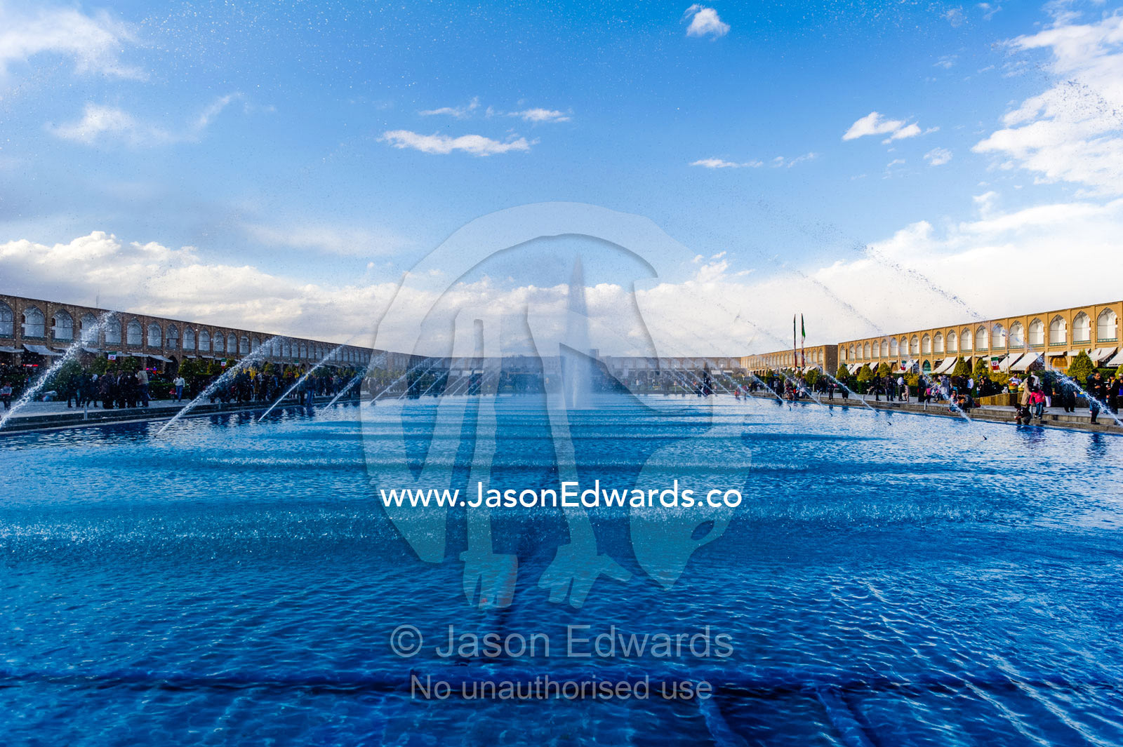 Water fountains spray into an enormous pond in an ancient bazaar. Naqsh-e Jahan Square, Isfahan, Isfahan Province, Islamic Republic of Iran.