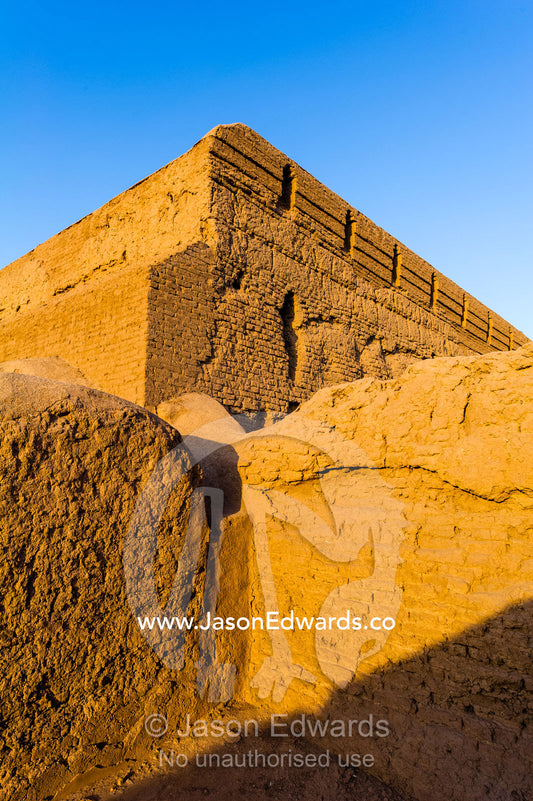 Sunset warms the walls of an ancient mud brick fortress overlooking the desert plain. Narin Castle, Meybod, Meybod County, Yazd Province, Islamic Republic of Iran.