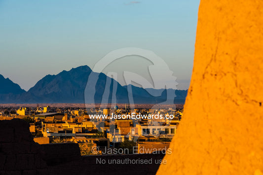 Sunset warms the walls of an ancient mud brick fortress overlooking the desert plain. Narin Castle, Meybod, Meybod County, Yazd Province, Islamic Republic of Iran.