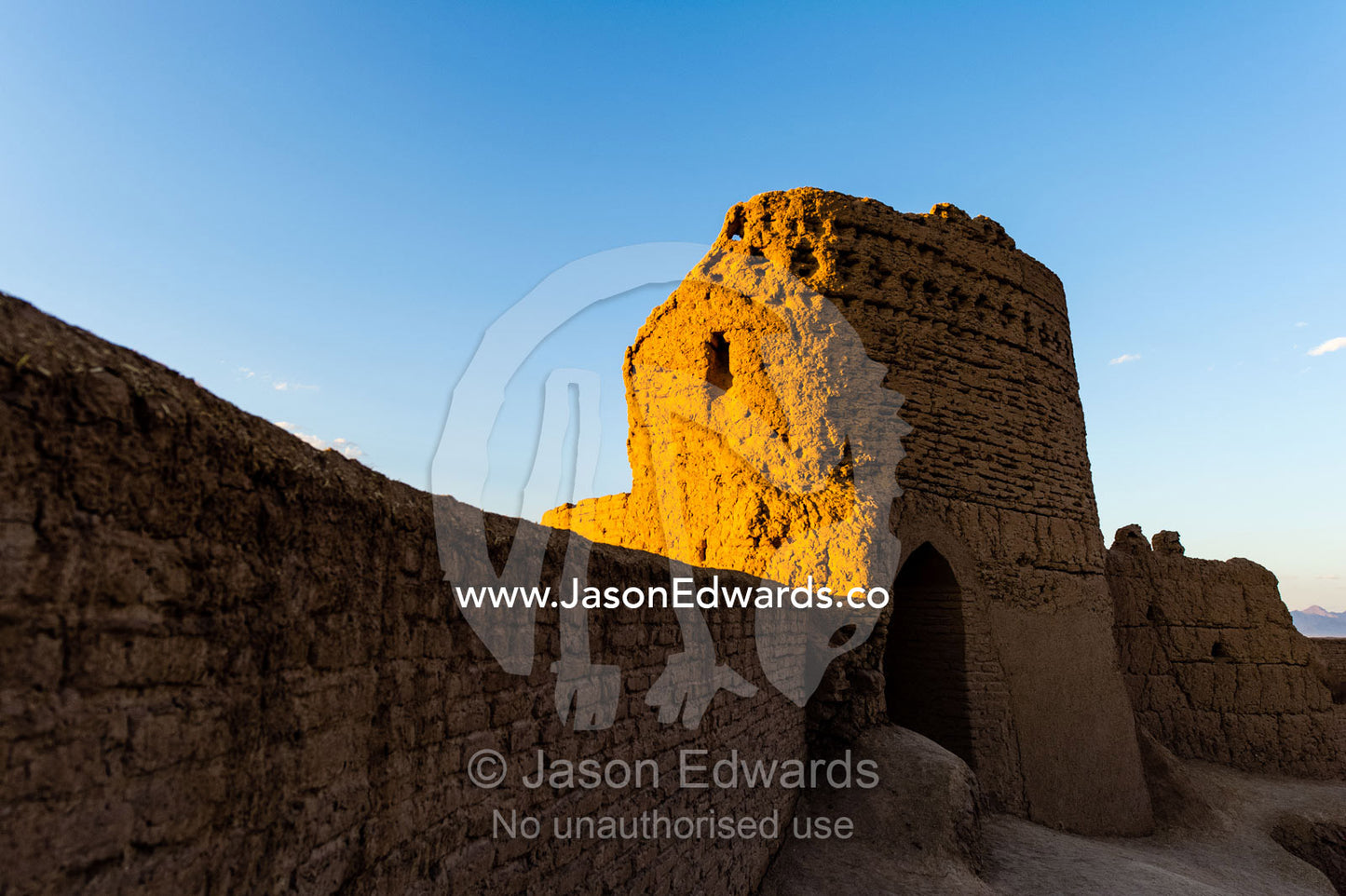 Sunset warms the walls of a watch tower in an ancient mud brick fortress overlooking the desert plain. Narin Castle, Meybod, Meybod County, Yazd Province, Islamic Republic of Iran.