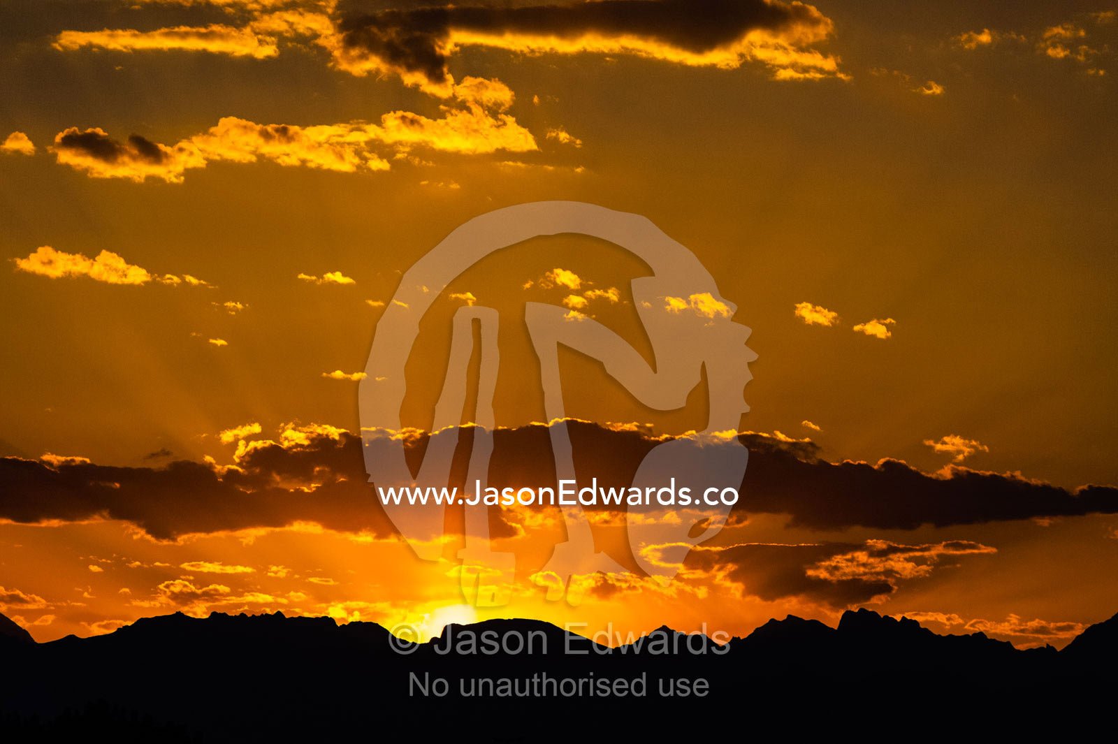 Sunset over the silhouette of jagged desert mountains. Narin Castle, Meybod, Meybod County, Yazd Province, Islamic Republic of Iran.
