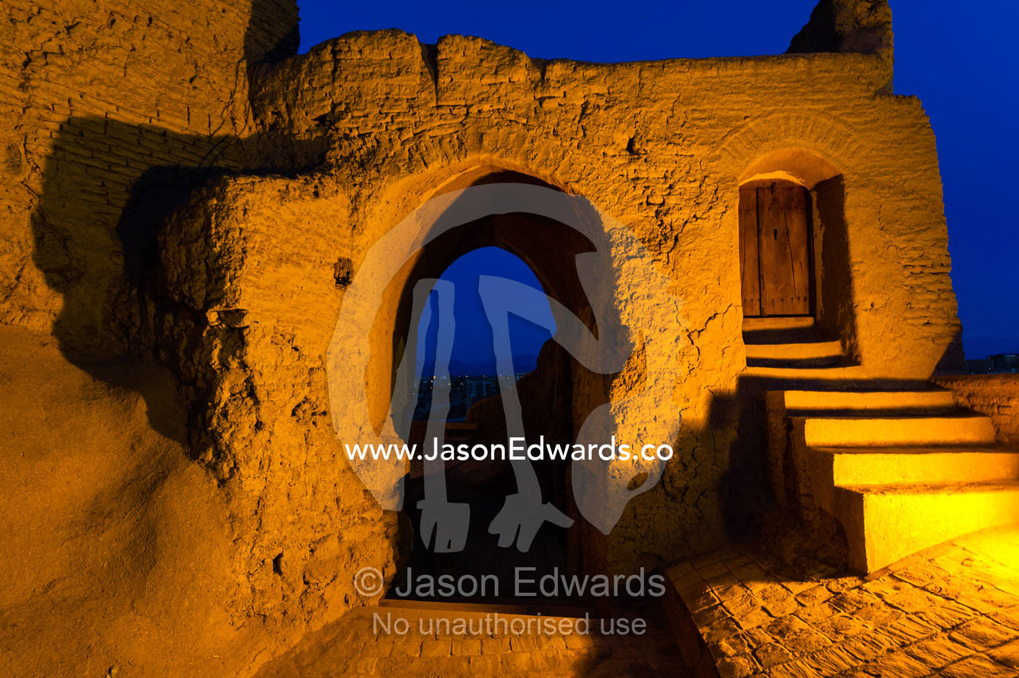 A gate in an ancient mud brick fortress overlooking the desert plain at night. Narin Castle, Meybod, Meybod County, Yazd Province, Islamic Republic of Iran.