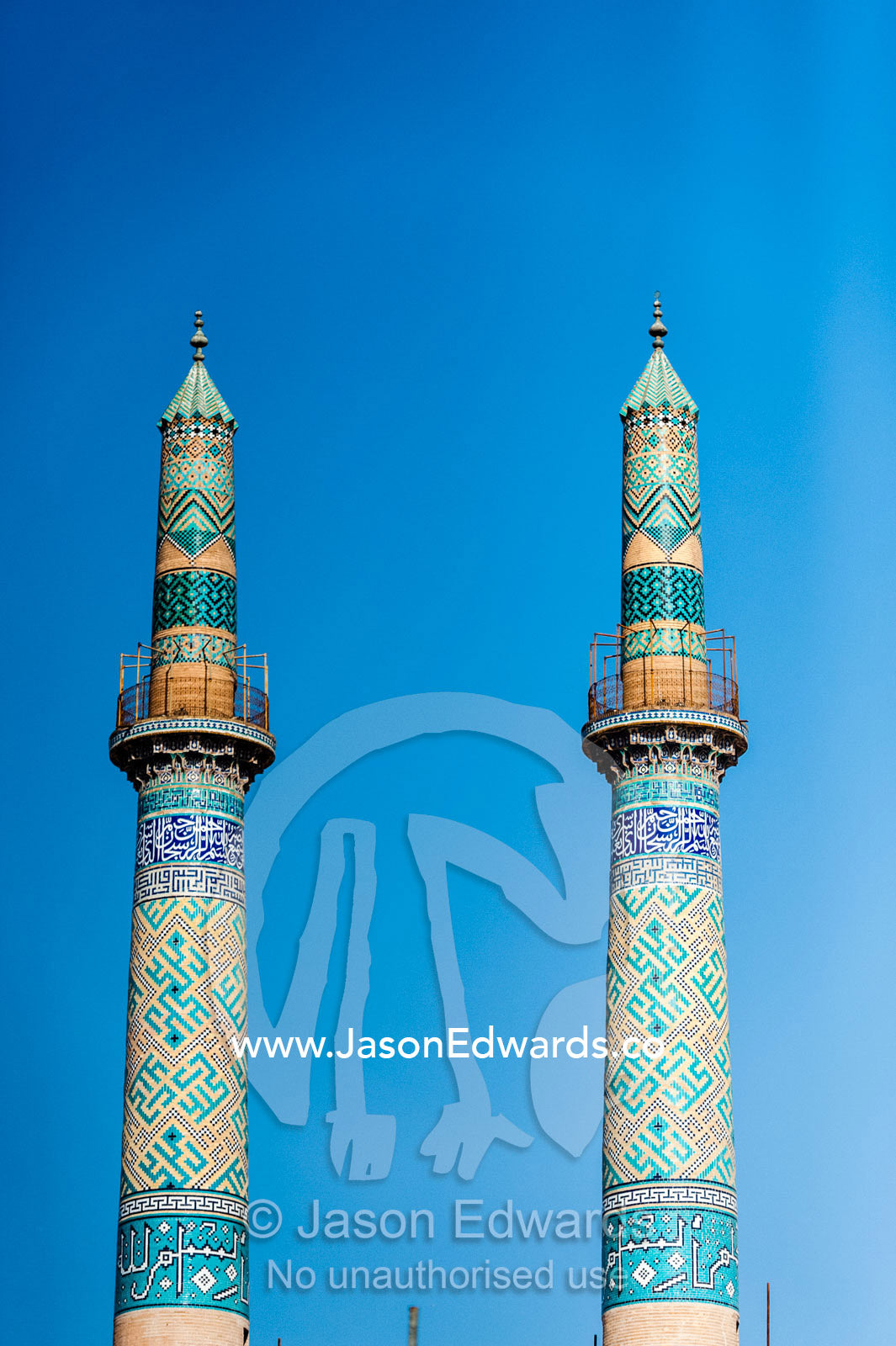 The towering blue tiled minarets of the Jame Mosque rise into a clear blue sky. Jame Mosque of Yazd, Yazd, Yazd Province, Islamic Republic of Iran.