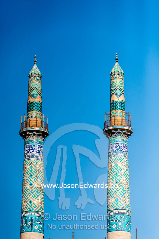 The towering blue tiled minarets of the Jame Mosque rise into a clear blue sky. Jame Mosque of Yazd, Yazd, Yazd Province, Islamic Republic of Iran.