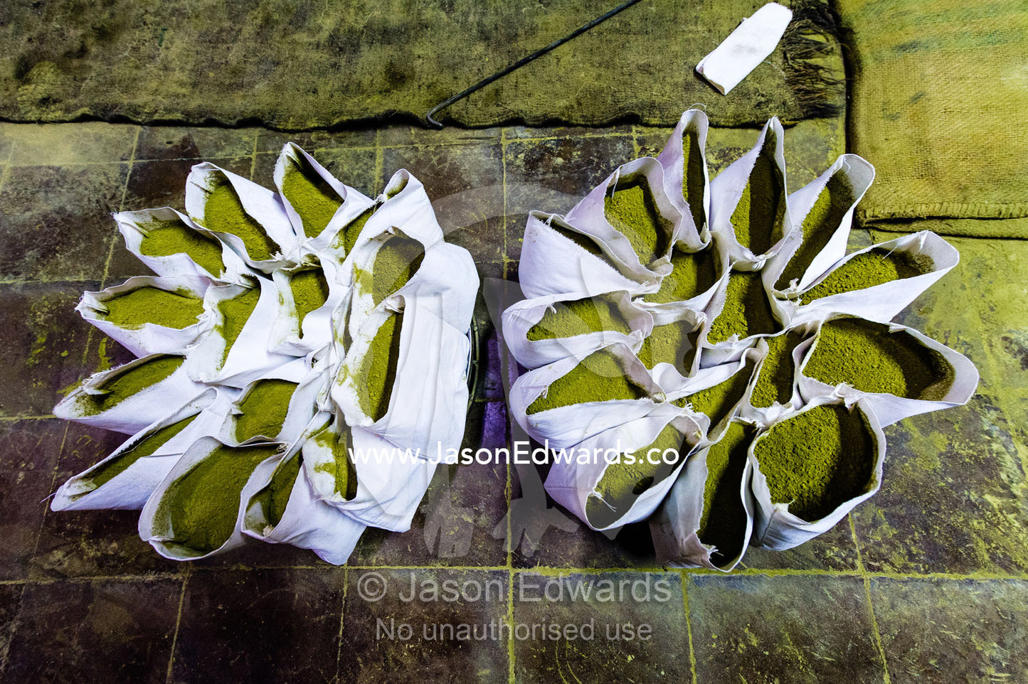 A labourer fills bags with henna for sale in an ancient henna mill. Yazd, Yazd Province, Islamic Republic of Iran.