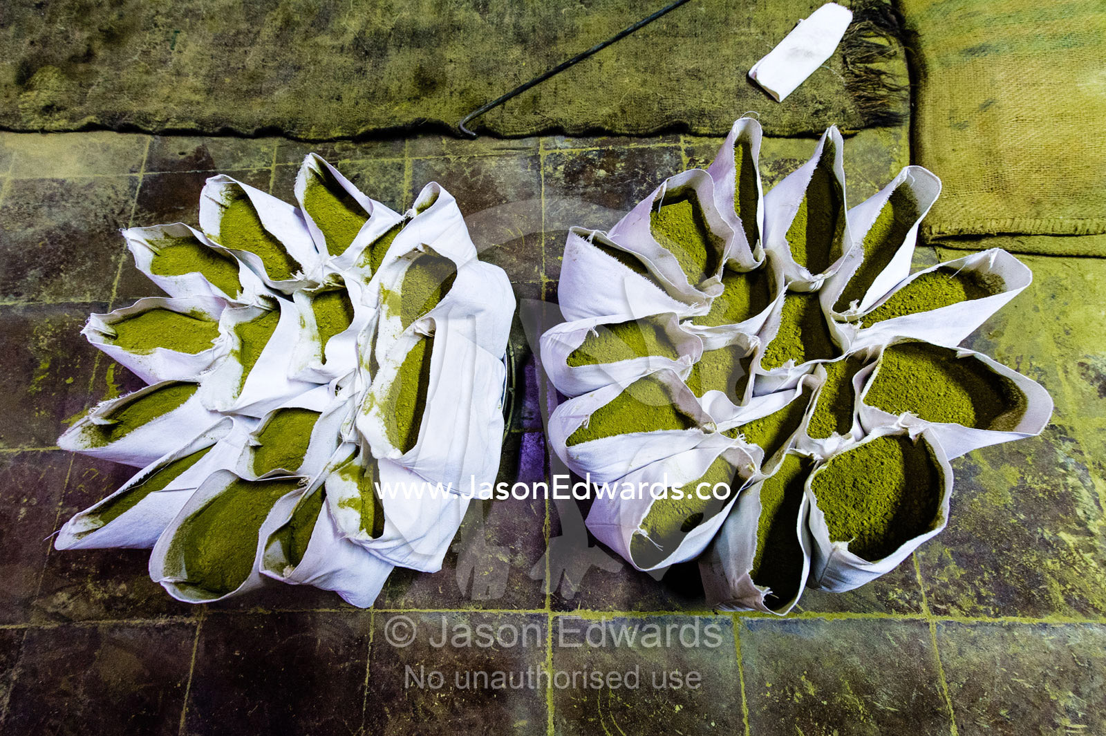 A labourer fills bags with henna for sale in an ancient henna mill. Yazd, Yazd Province, Islamic Republic of Iran.