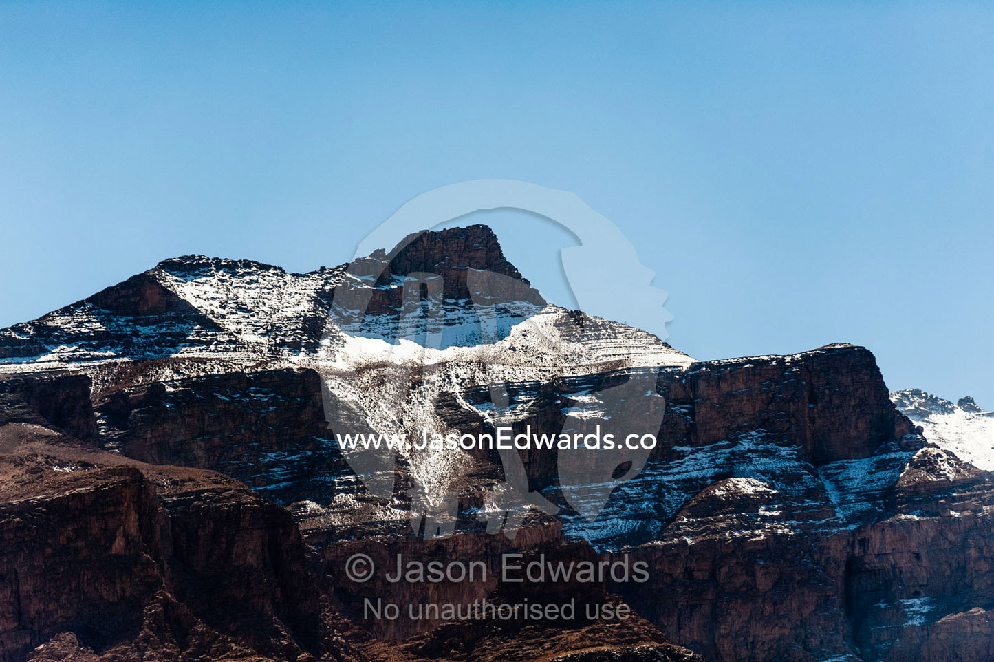 Snow-capped mountain peaks rise above the desert plain. Shir Kuh Mountain, Yazd, Yazd Province, Islamic Republic of Iran.
