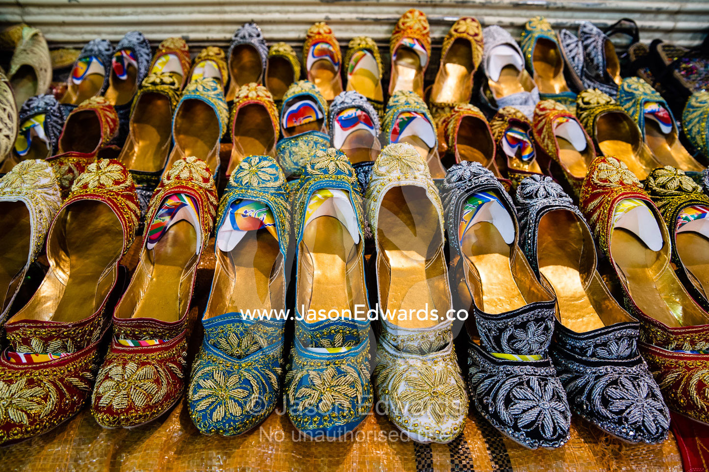 Rows of slippers decorated in fine gold stitching for sale in a bazaar. Vakil Bazaar, Shiraz, Islamic Republic of Iran.