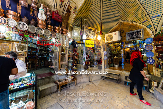 A woman browsing for souvenirs in a bazaar. Saraye Moshir, Shiraz, Islamic Republic of Iran.
