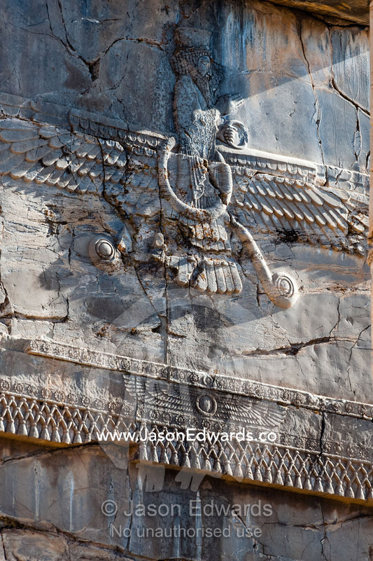 A symbol of the winged discs of Fravahr carved into the gates of Hadish Tachara Palace. Persepolis, Shiraz, Fars Province, Islamic Republic of Iran.
