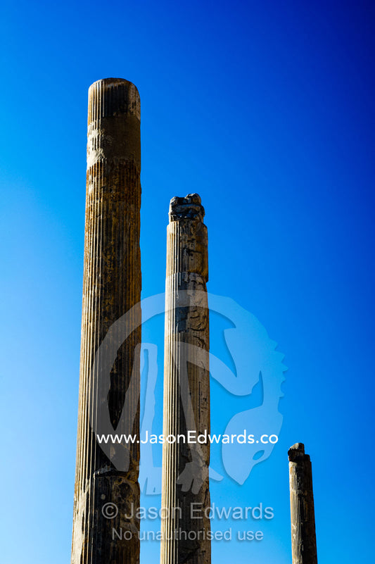 The towering stone columns of the Apandana Palace rising into a clear blue sky. Persepolis, Shiraz, Fars Province, Islamic Republic of Iran.