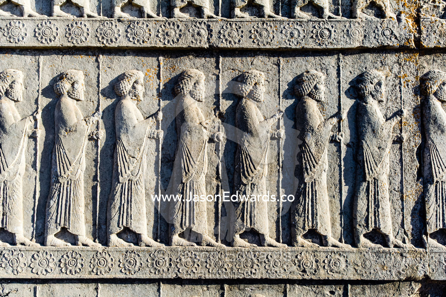 A limestone frieze of immortal guards carrying spears carved into a stone wall at Persepolis. Persepolis, Shiraz, Fars Province, Islamic Republic of Iran.