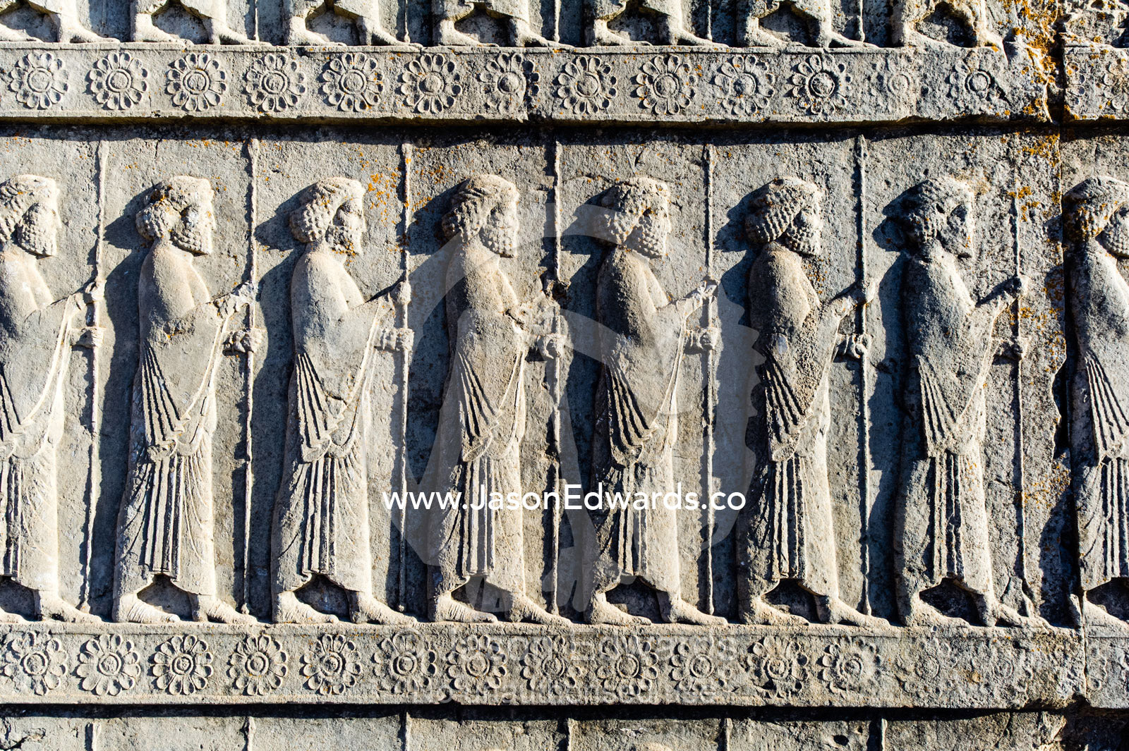 A limestone frieze of immortal guards carrying spears carved into a stone wall at Persepolis. Persepolis, Shiraz, Fars Province, Islamic Republic of Iran.
