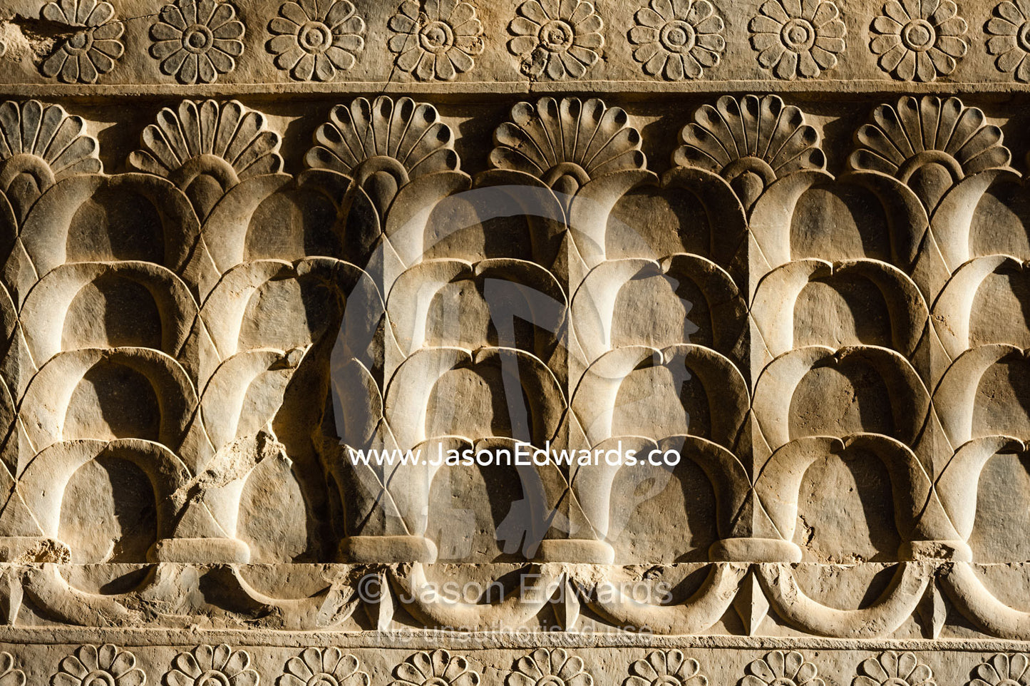 A limestone frieze of lotus flowers carved into a stone wall at Persepolis. Persepolis, Shiraz, Fars Province, Islamic Republic of Iran.