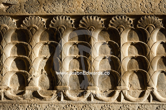 A limestone frieze of lotus flowers carved into a stone wall at Persepolis. Persepolis, Shiraz, Fars Province, Islamic Republic of Iran.