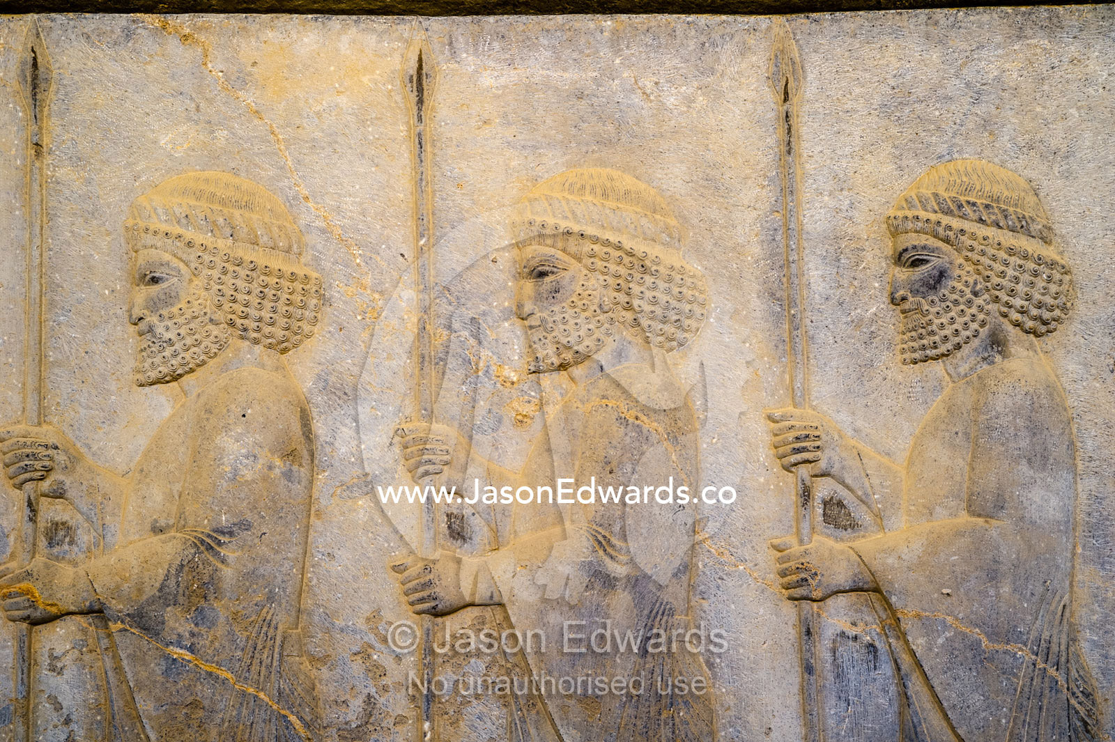 A limestone frieze of immortal guards carrying spears carved into a stone wall at Persepolis. Persepolis, Shiraz, Fars Province, Islamic Republic of Iran.