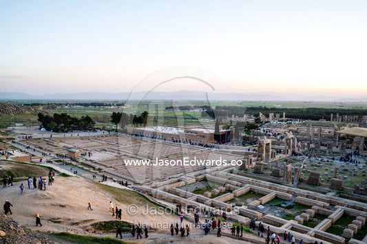 Tourists move through the ruins of Persepolis during the sunset afterglow. Persepolis, Shiraz, Fars Province, Islamic Republic of Iran.