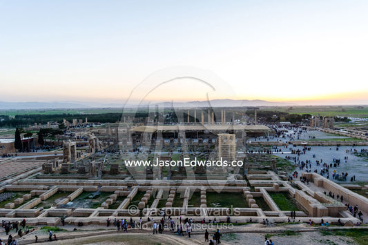Tourists move through the ruins of Persepolis during the sunset afterglow. Persepolis, Shiraz, Fars Province, Islamic Republic of Iran.