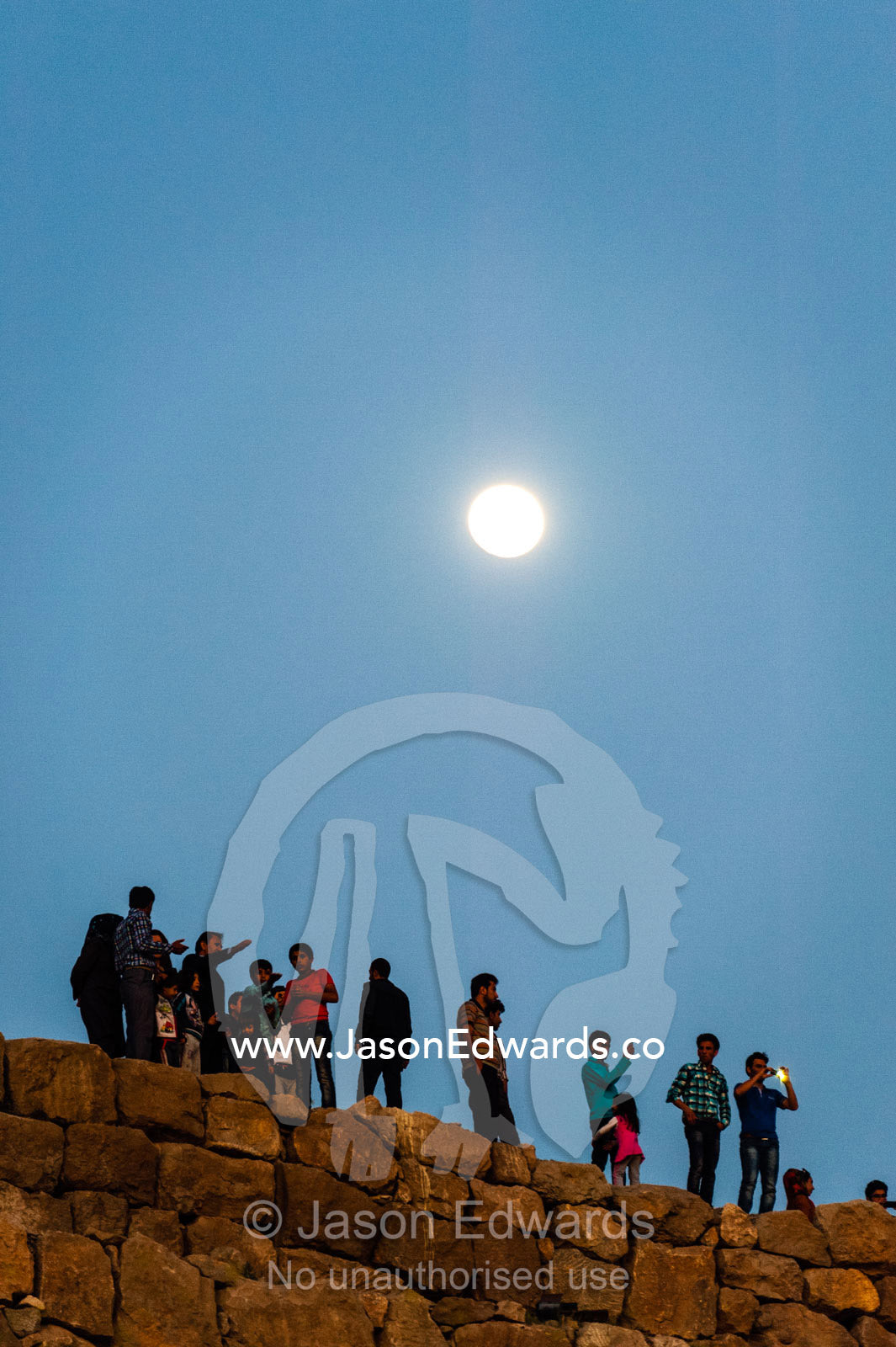 Iranian tourists photograph the ruins of Persepolis beneath a rising moon. Persepolis, Shiraz, Fars Province, Islamic Republic of Iran.