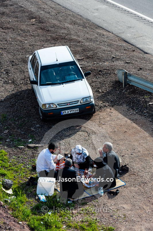 A family of Bedouins prepare a meal beside a highway in the desert. Qom Province, Islamic Republic of Iran.