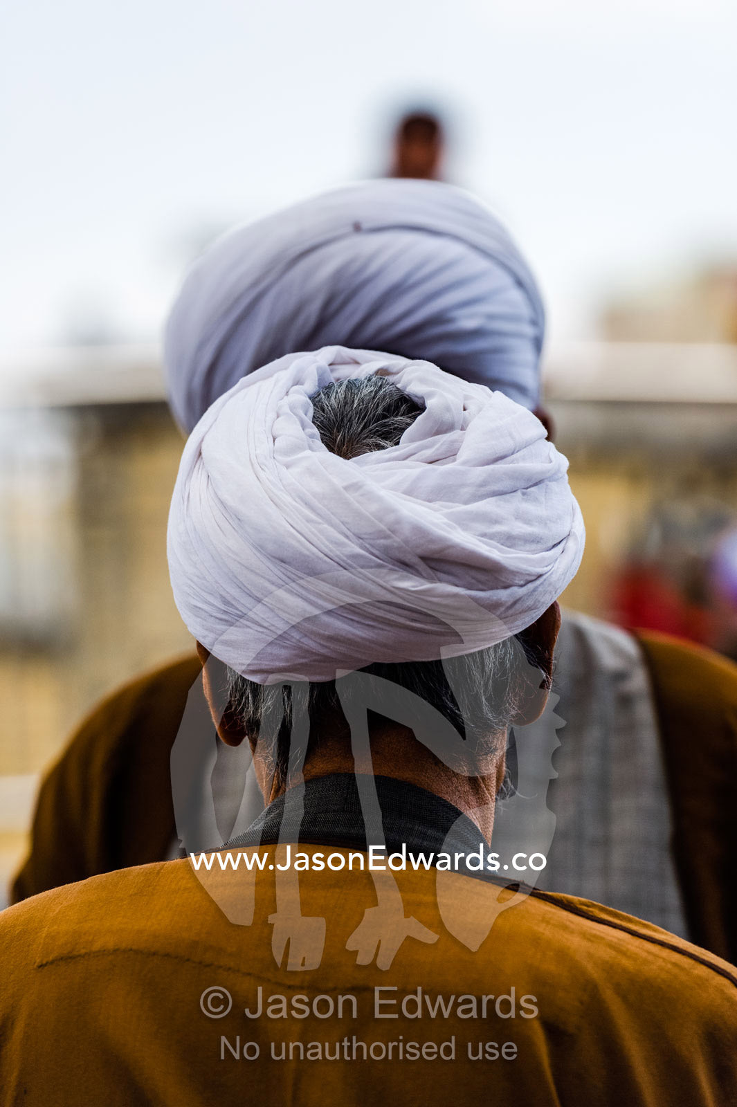 A pair of clergyman wearing turbans and woven cloaks in deep conversation outside a shrine. Fatima Masumeh Shrine, Qom, Qom Province, Islamic Republic of Iran.