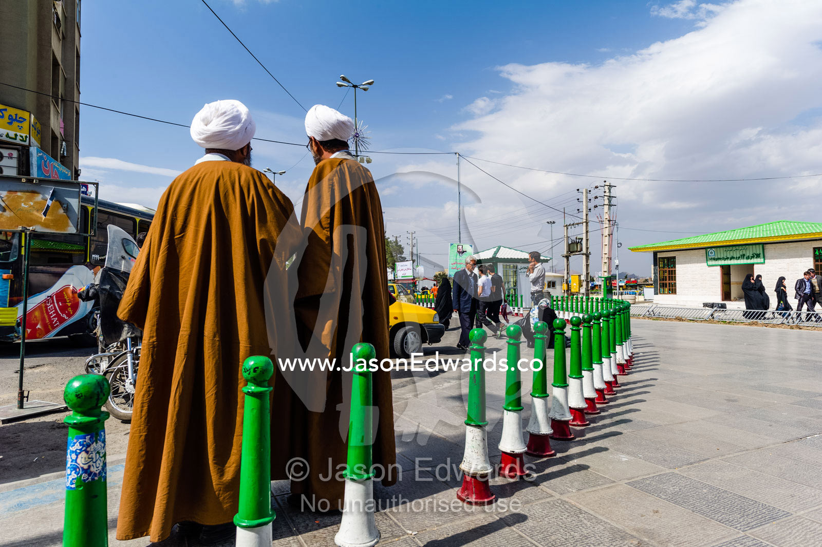 A pair of clergyman wearing turbans and woven cloaks in deep conversation outside a shrine. Fatima Masumeh Shrine, Qom, Qom Province, Islamic Republic of Iran.