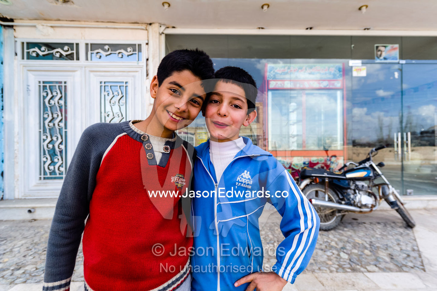 Two boys pose for a portrait beside their motor bike in a small mountain village. Niasar, Neyasar District, Kashan County, Isfahan Province, Islamic Republic of Iran.