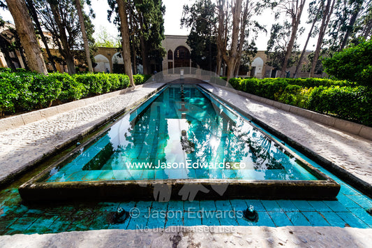 A spring fed water feature running between a row of trees in an historical Persian garden. Fin Garden, Kashan, Isfahan, Islamic Republic of Iran.