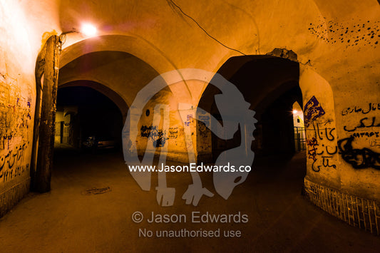 Ancient archways over laneways illuminated by light bulbs in an old neighborhood. Kashan, Isfahan, Islamic Republic of Iran.