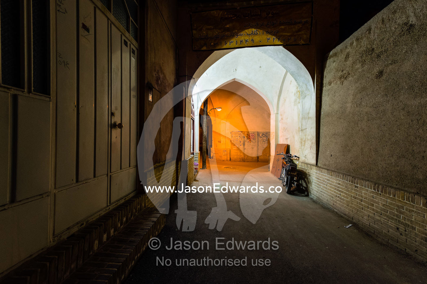 Ancient archways over laneways illuminated by light bulbs in an old neighborhood. Kashan, Isfahan, Islamic Republic of Iran.