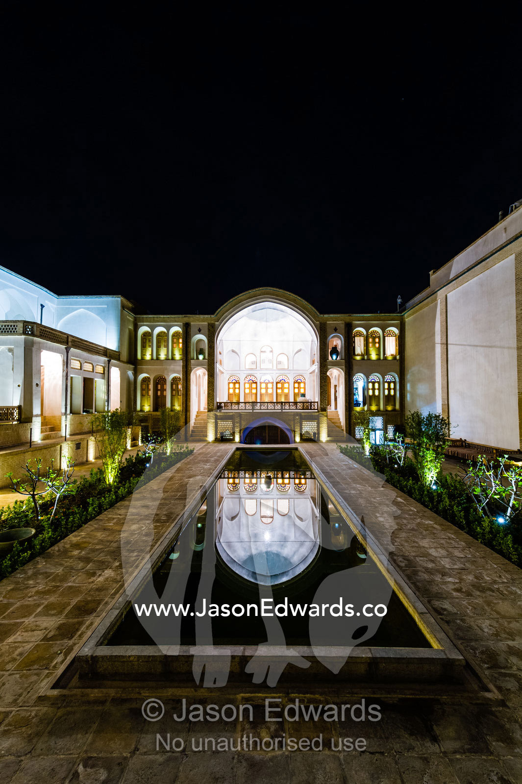 The reflection of an historic house in it's garden pond at night. Tabatabayi House, Kashan, Isfahan, Islamic Republic of Iran.