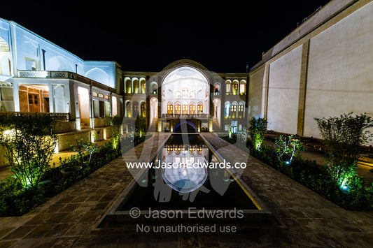 The reflection of an historic house in it's garden pond at night. Tabatabayi House, Kashan, Isfahan, Islamic Republic of Iran.