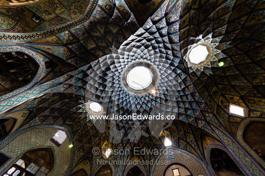 Skylights illuminate the vaulted spiralling geometric ceiling of an ancient bazaar. The Bazaar of Kashan, Kashan, Isfahan, Islamic Republic of Iran.
