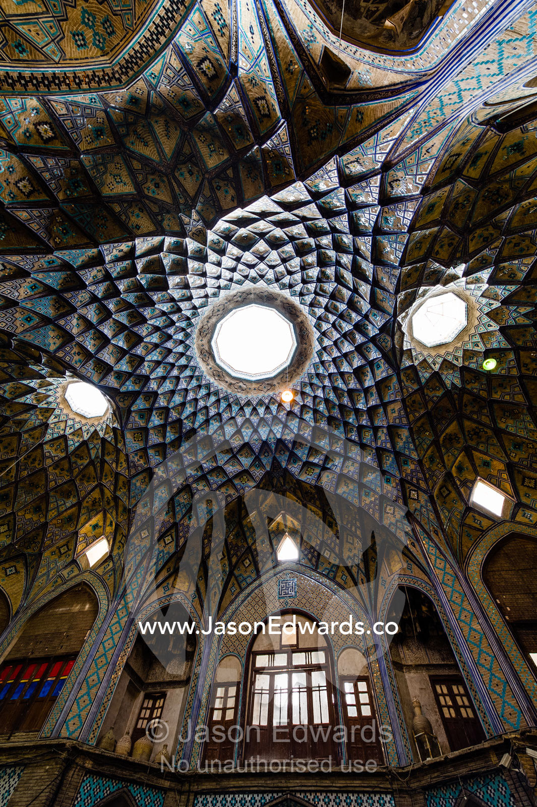 Skylights illuminate the vaulted spiralling geometric ceiling of an ancient bazaar. The Bazaar of Kashan, Kashan, Isfahan, Islamic Republic of Iran.