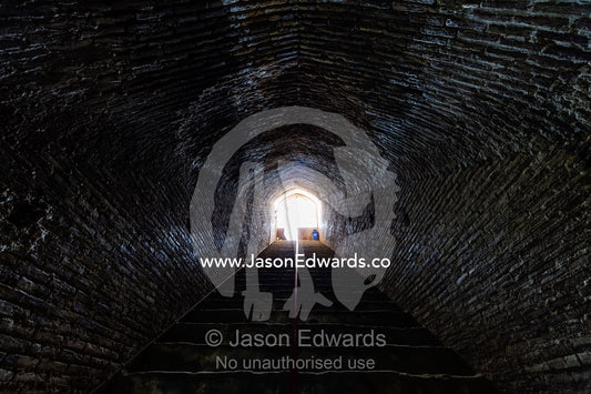 Handmade bricks line an arched tunnel and stairwell descending to an ancient underground city used for defense. Ouyi, Noushabad, Kashan, Isfahan province, Islamic Republic of Iran.