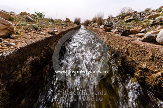 An aqueduct known as a falaj transports water across a barren desert. Barzrud Rural District, Natanz County, Isfahan Province, Islamic Republic of Iran.