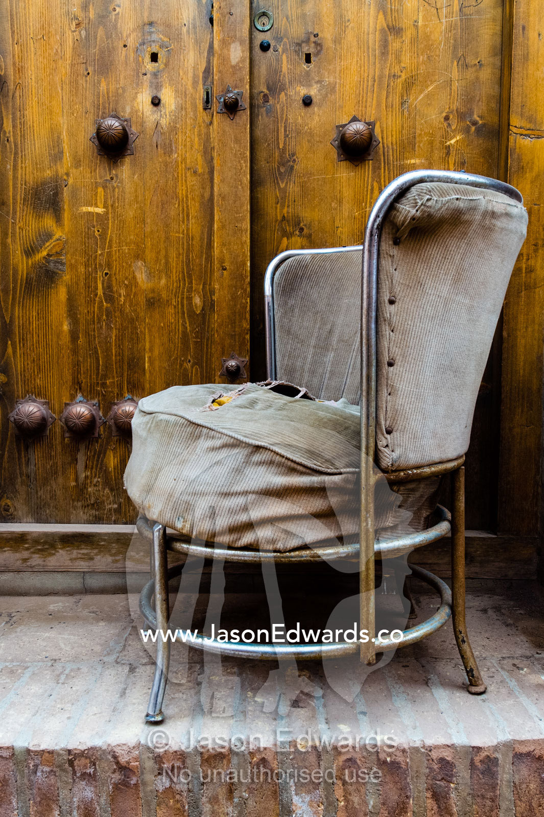A worn out retro chair sitting on the front doorstep of a village house. Abyaneh Village, Abyaneh, Barzrud Rural District, Natanz County, Isfahan Province, Islamic Republic of Iran.