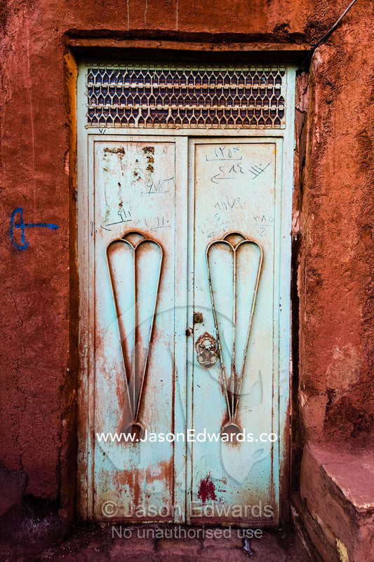 A pair of peeling steel doors in a red ochre house wall. Abyaneh Village, Abyaneh, Barzrud Rural District, Natanz County, Isfahan Province, Islamic Republic of Iran.
