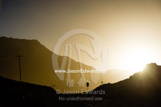 The silhouette of road signs and electricity poles along a mountain road. Abyaneh, Barzrud Rural District, Natanz County, Isfahan Province, Islamic Republic of Iran.
